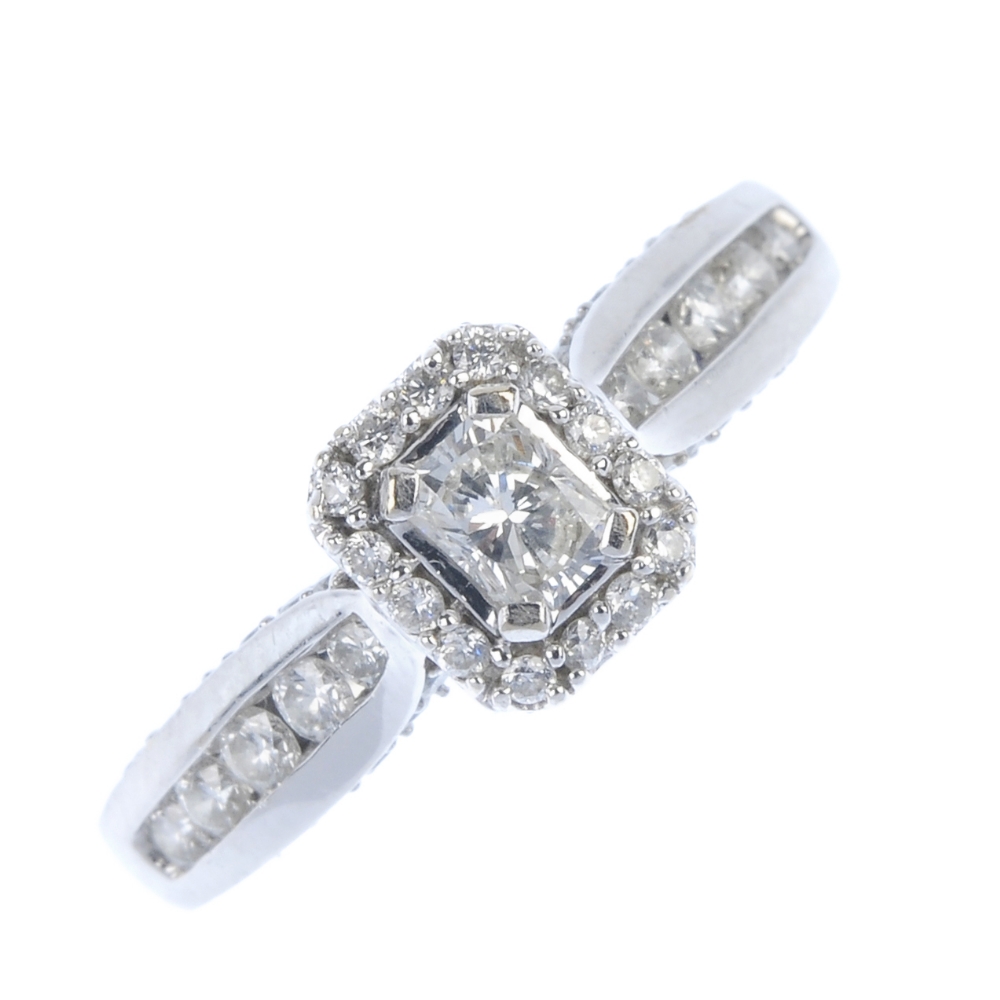 An 18ct gold diamond dress ring. The rectangular-shape diamond, within a brilliant-cut diamond