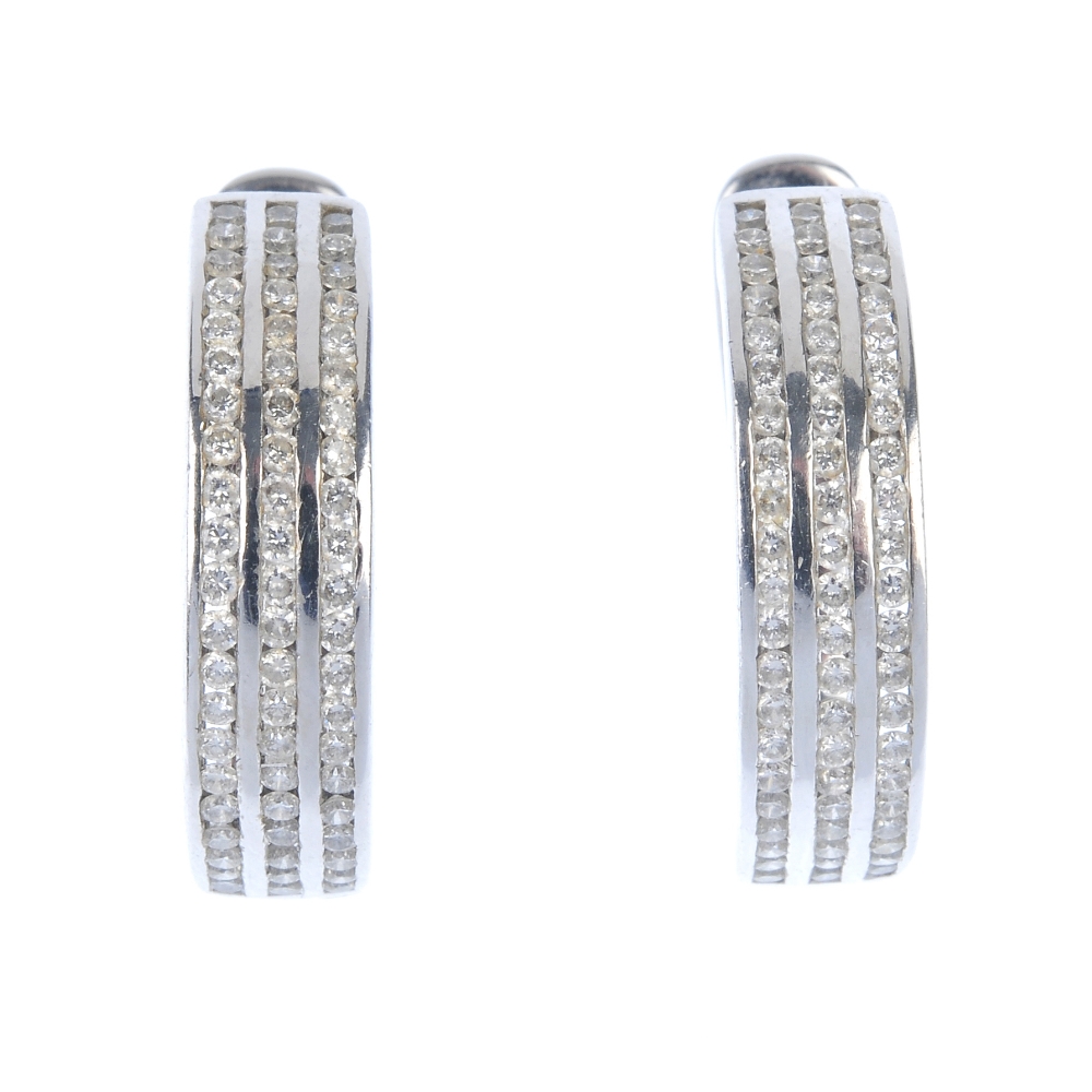 A pair of diamond earrings. Each designed as three brilliant-cut diamond lines, inset to the