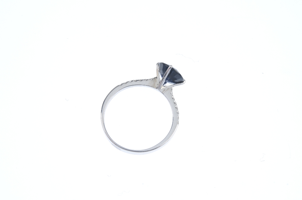 A sapphire and diamond ring. The circular-shape sapphire, to the brilliant-cut diamond line sides - Image 3 of 3