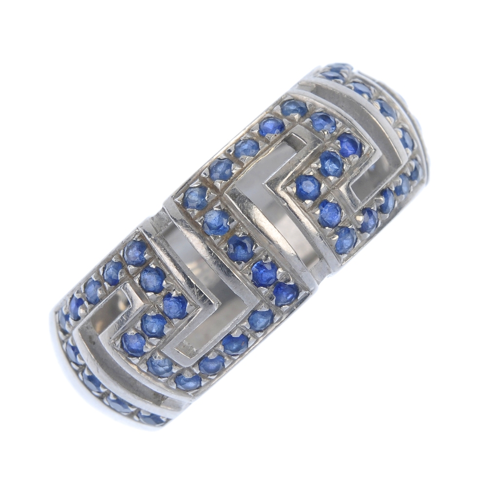 VERSACE - an 18ct gold sapphire band ring. Of openwork design, the circular-shape sapphire Greek-key