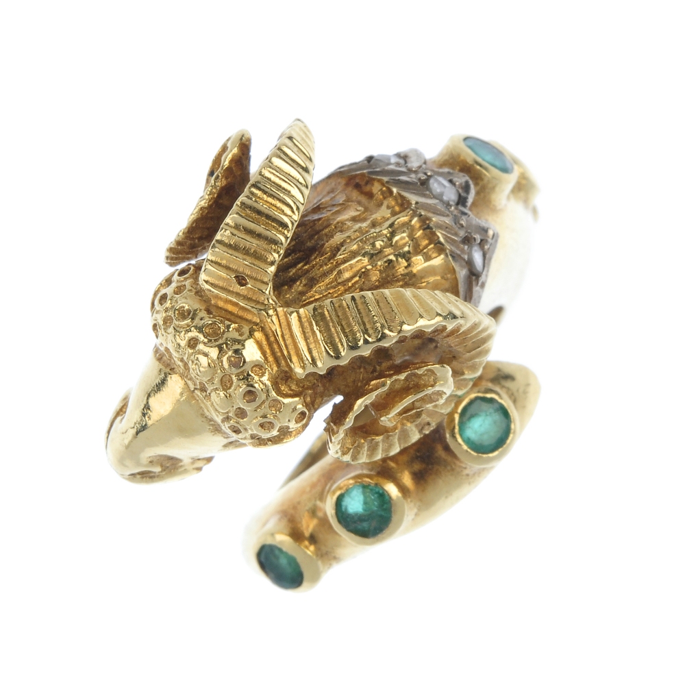 An emerald diamond and ruby dress ring. Designed as a textured rams head, with ruby eye detail and