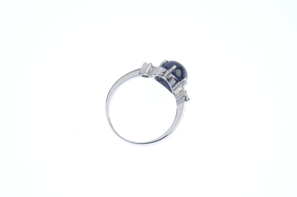 A sapphire and diamond three-stone ring. The circular sapphire cabochon, to the brilliant-cut - Image 3 of 3