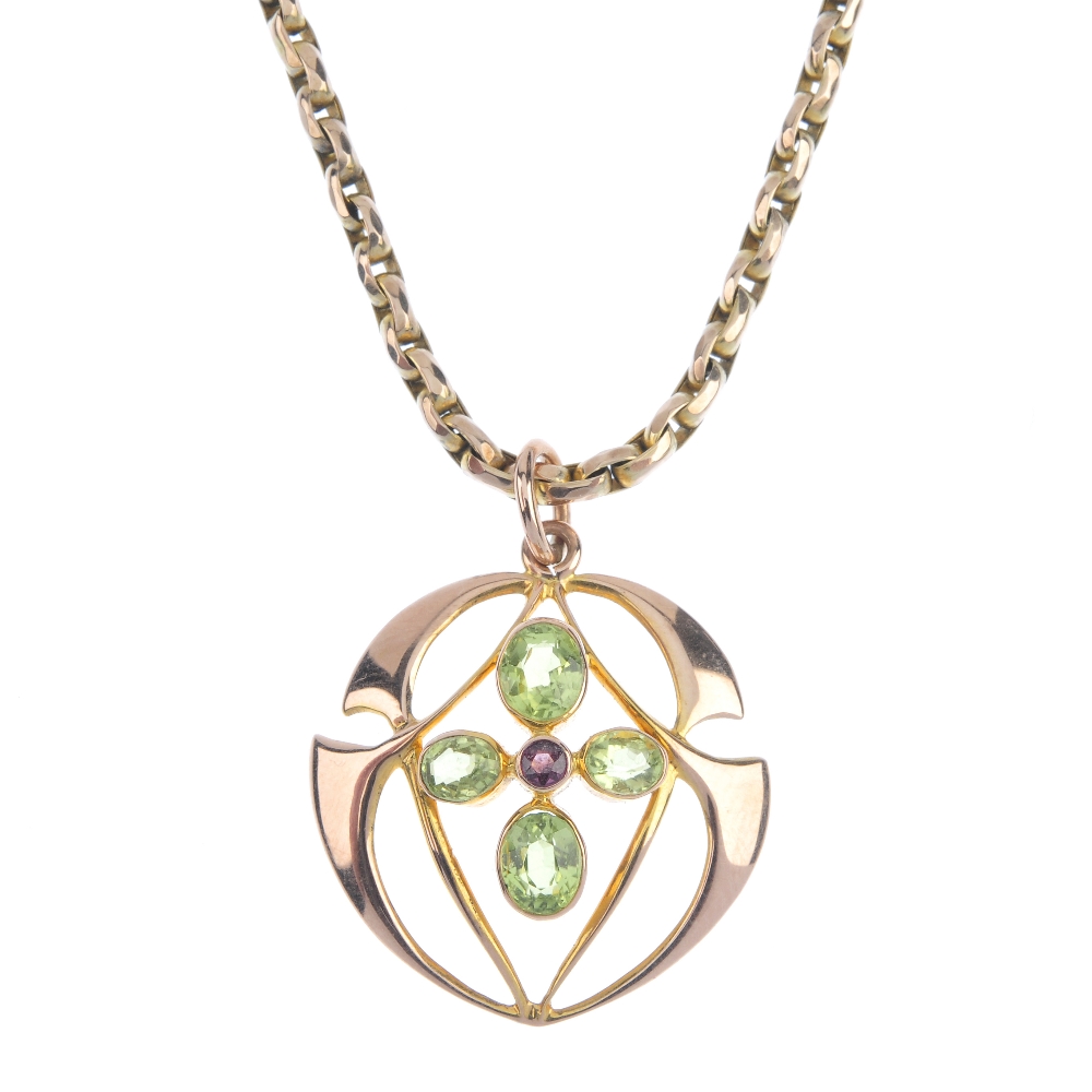 An early 20th century gem-set pendant. The circular-shape garnet, within an oval-shape peridot