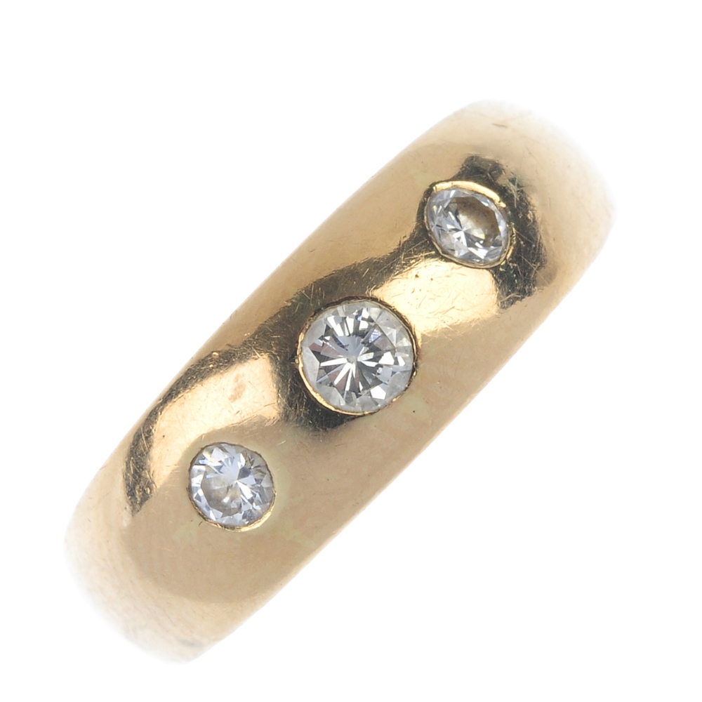 A mid 20th century diamond three-stone ring. The graduated brilliant-cut diamond line, inset to