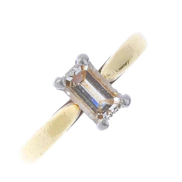 (174110) An 18ct gold diamond single-stone ring. The rectangular-shape diamond, to the tapered