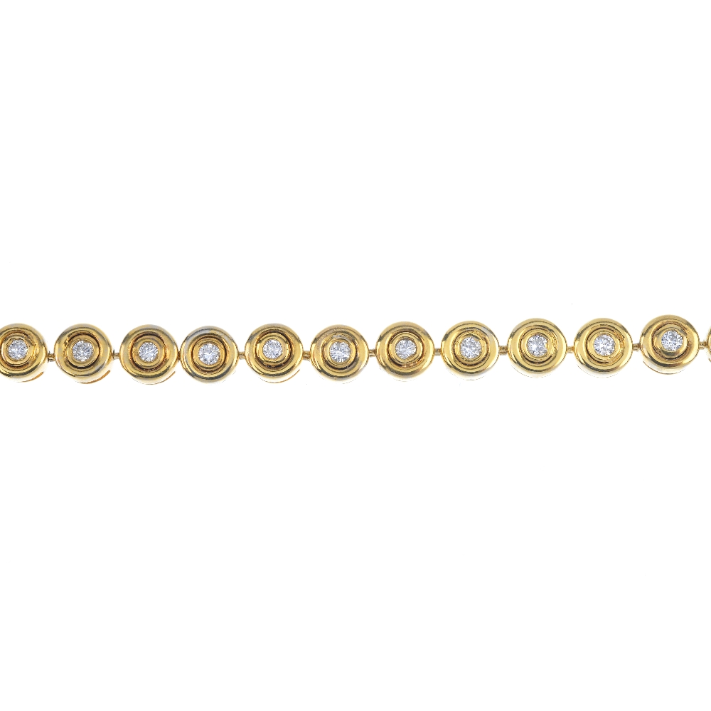 A 9ct gold diamond line bracelet. Designed as a series of brilliant-cut diamond, wide collet