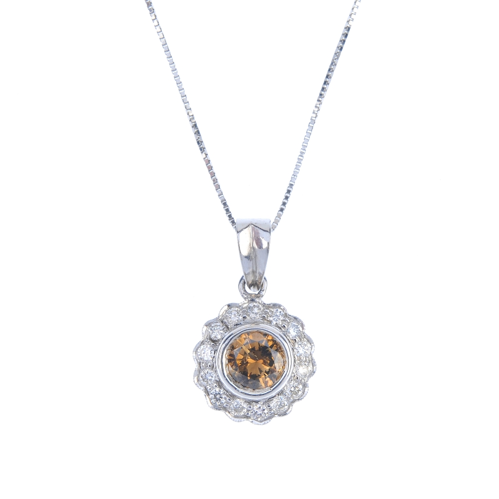 An 18ct gold coloured diamond and diamond cluster pendant. The brilliant-cut 'brown' diamond, within