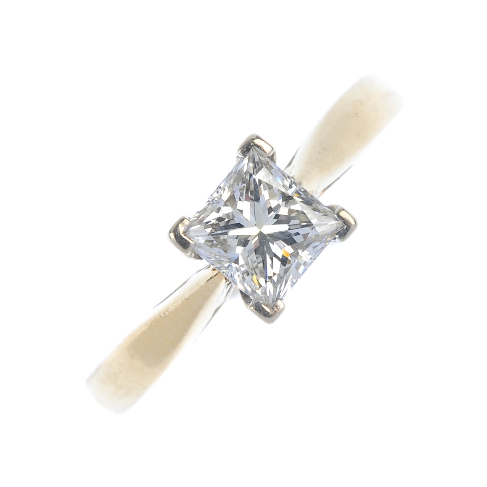 A diamond single-stone ring. The square-shape diamond, to the tapered shoulders and plain band.