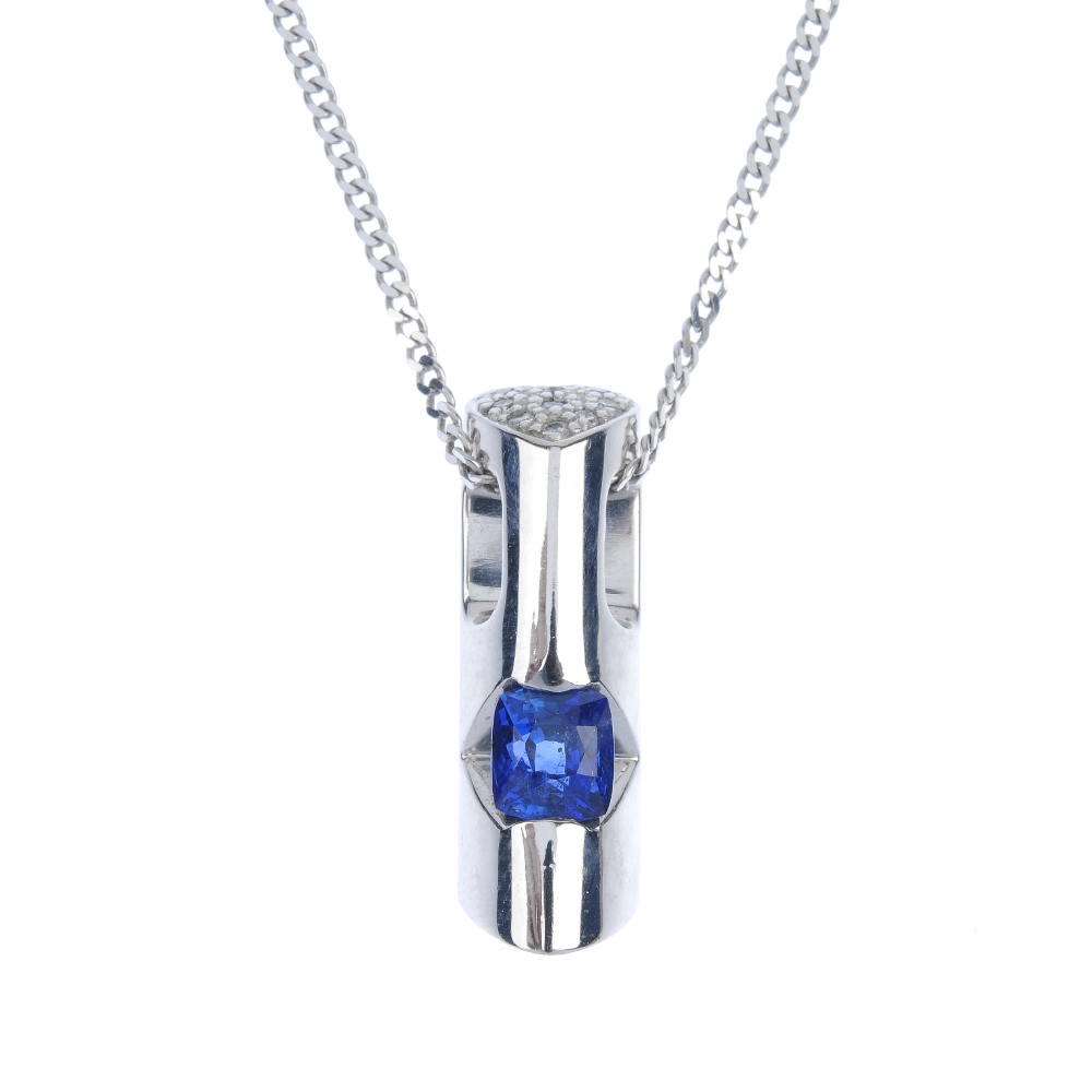 A sapphire and diamond pendant. The cushion-shape sapphire, inset to the tapered bar, with