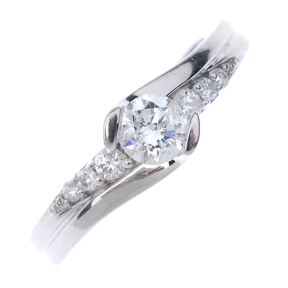 An 18ct gold diamond crossover ring. The brilliant-cut diamond, to the similarly-cut diamond three-