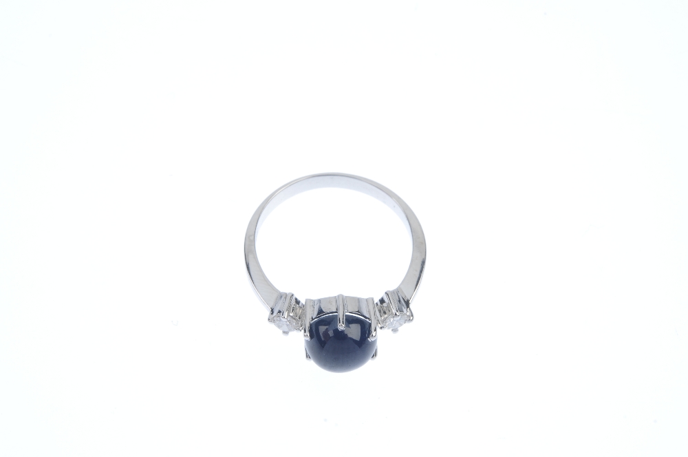 A sapphire and diamond three-stone ring. The circular sapphire cabochon, to the brilliant-cut - Image 2 of 3
