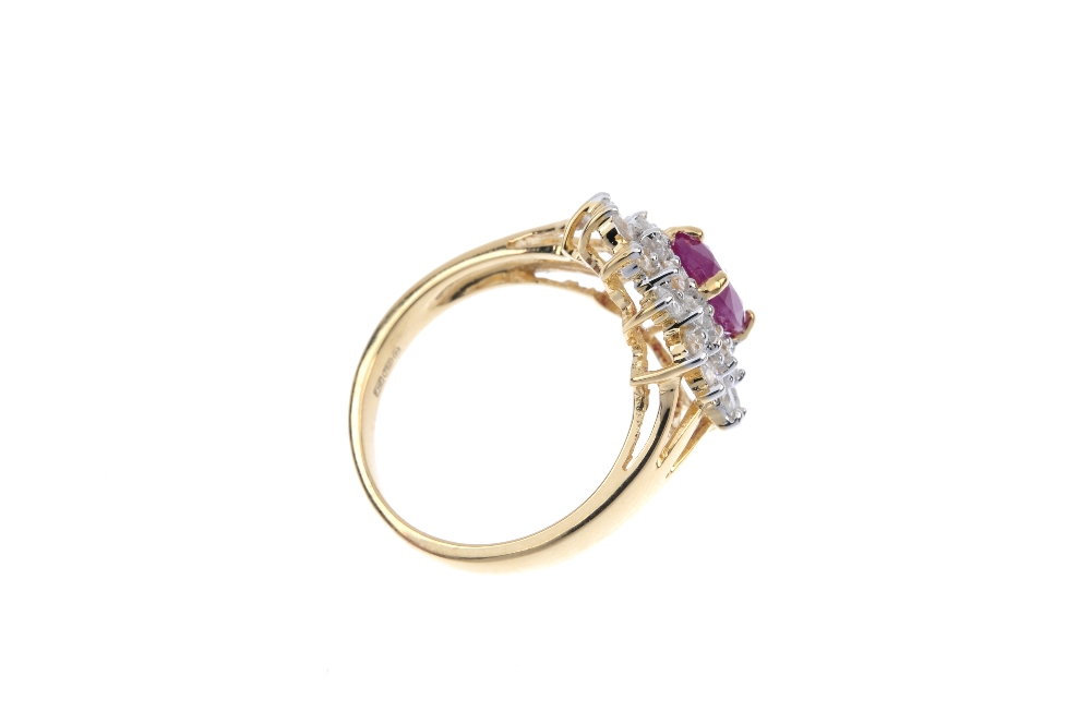An 18ct gold ruby and diamond cluster ring. The oval-shape ruby, within a brilliant-cut diamond - Image 4 of 4