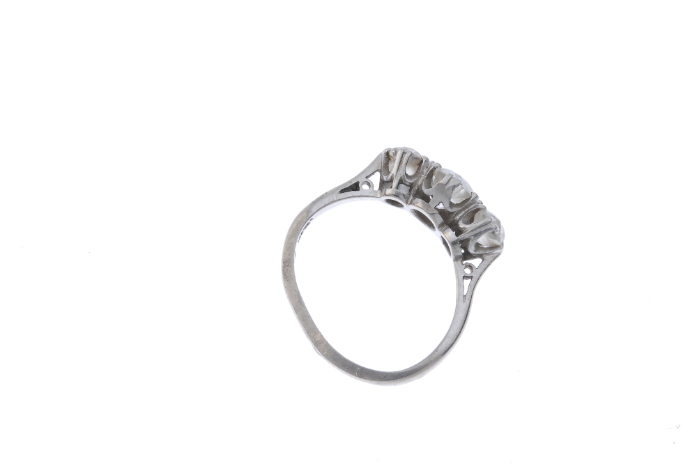 An 18ct gold diamond three-stone ring. The graduated old-cut diamond line, to the plain band. - Image 3 of 3