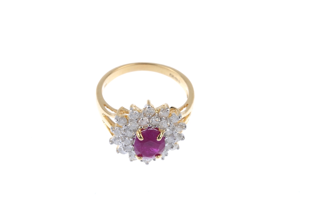 An 18ct gold ruby and diamond cluster ring. The oval-shape ruby, within a brilliant-cut diamond - Image 2 of 4