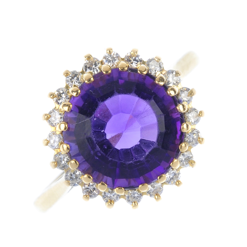 An 18ct gold amethyst and diamond cluster ring. The circular-shape amethyst, within a brilliant-