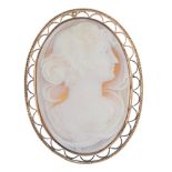 A cameo brooch. Of oval outline, the shell carved to depict a lady with hair tied back, to the