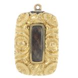 A mid Victorian gold mourning pendant. The rectangular glazed hair panel, to the floral border