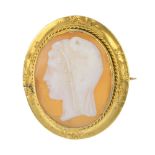 A cameo brooch. Of oval outline, the shell cameo depicting the profile of a hooded man, to the