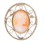 A cameo brooch. The oval cameo a typical profile of a lady, to the open scrollwork surround.