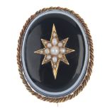 A late 19th century gold split pearl and onyx mourning brooch. The oval-shape onyx cabochon with a