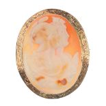 A cameo brooch. The shell carved to depict two Spartan soldiers, to the engraved scrolling border.