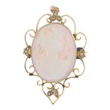A cameo brooch. The pale pink shell carved to depict the profile of a lady in a classical robe, to