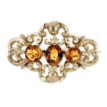A late Victorian gold citrine brooch, circa 1880. The oval-shape citrine, with circular-shape