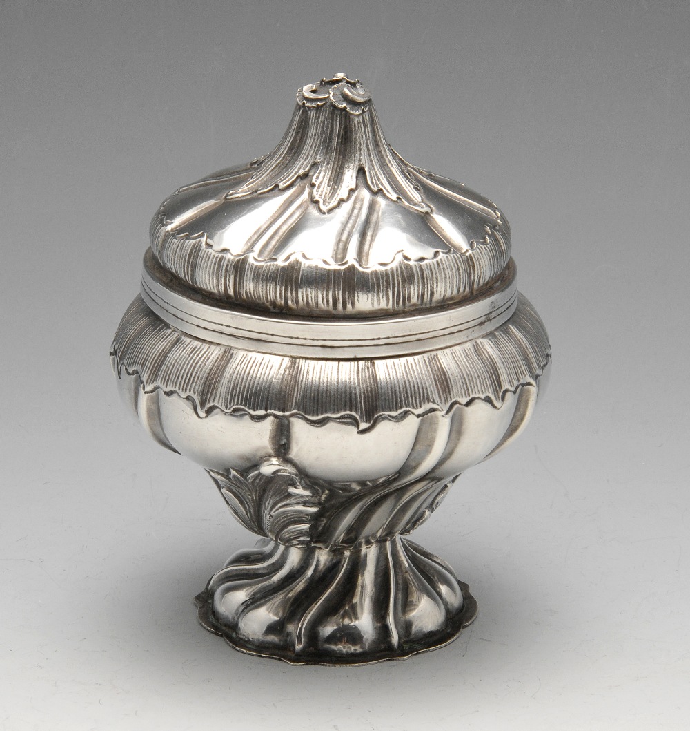 A small continental bowl and cover of wrythen moulded bulbous form to a footed base, embossed with