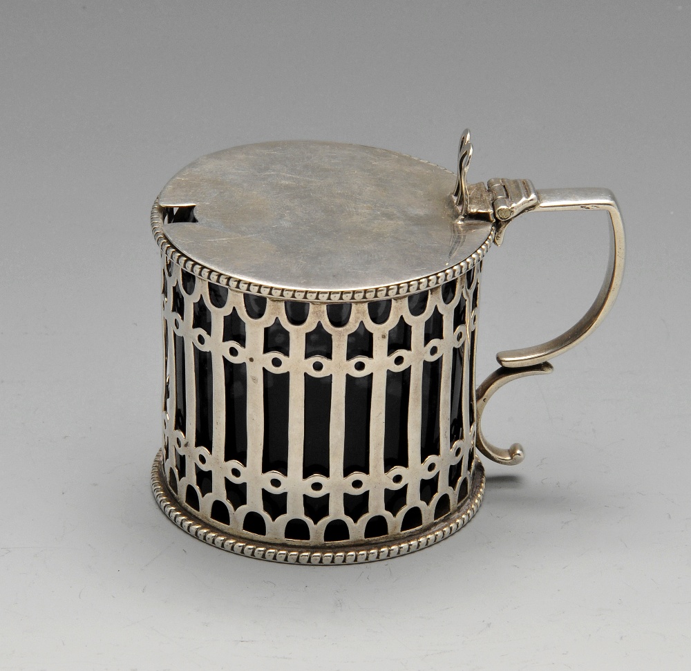 A Victorian silver drum mustard pot of pierced openwork form and blue glass liner. Hallmarked