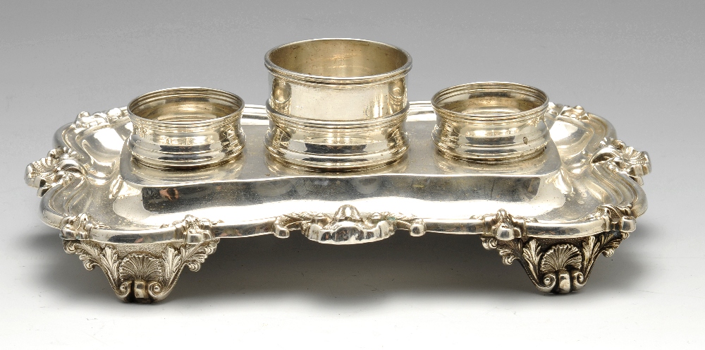 An early Victorian silver desk ink stand, the shaped base having shell moulded and reeded rim