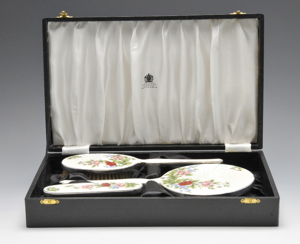 A 1960's cased silver mounted three piece dressing table set, comprising hand mirror hair brush