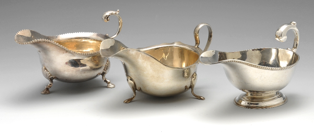 A 1930's silver sauce boat of typical bellied form having a shaped rim and raised on three