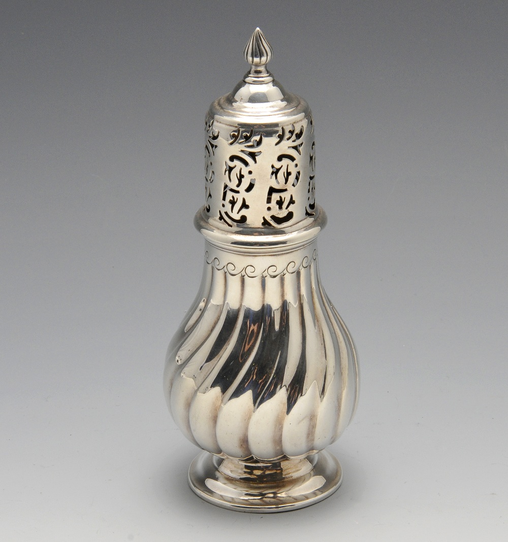 A late Victorian silver caster, of fluted pear form having pierced cover and flame finial, raised