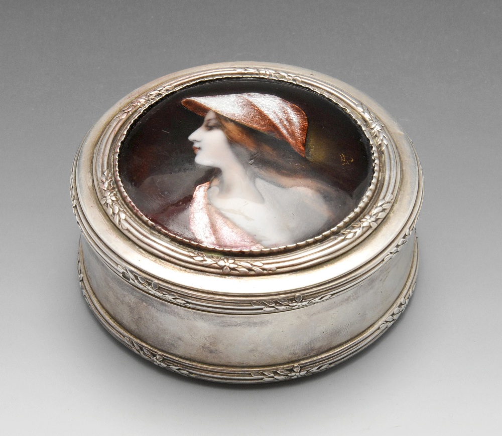 A French silver box of circular form with reeded borders and floral spray accents, the hinged