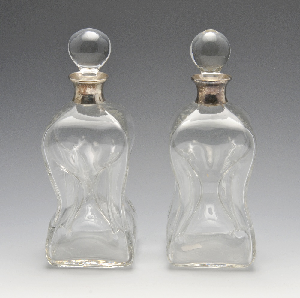 A pair of modern silver mounted clear glass glug-glug decanters, with silver collars and spherical