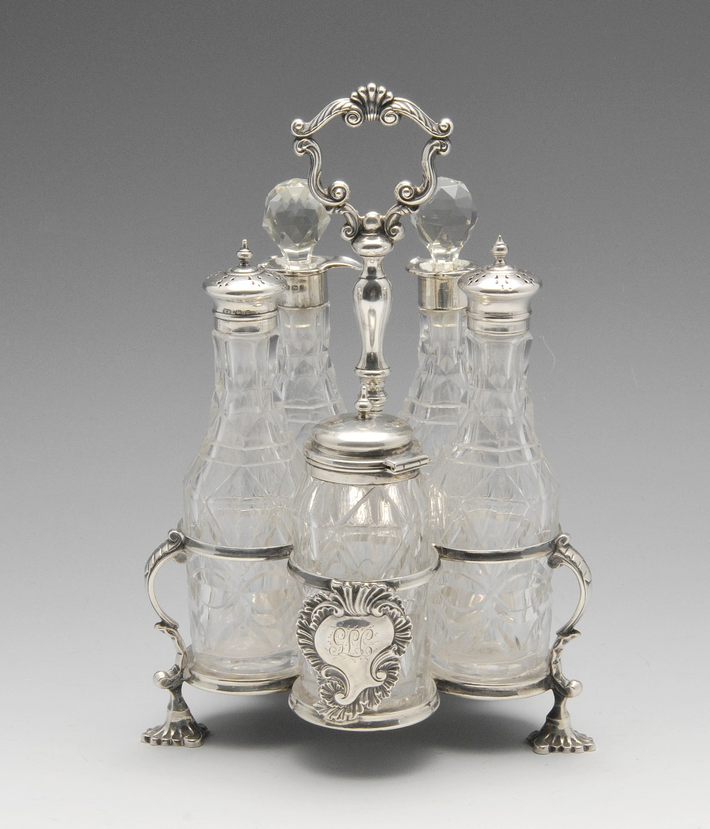 A late Victorian silver cruet stand for five bottles, having central baluster stem leading to a