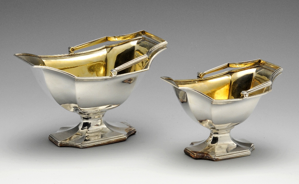 Two George III silver graduated sugar baskets, each of fluted pedestal form with reeded rims and