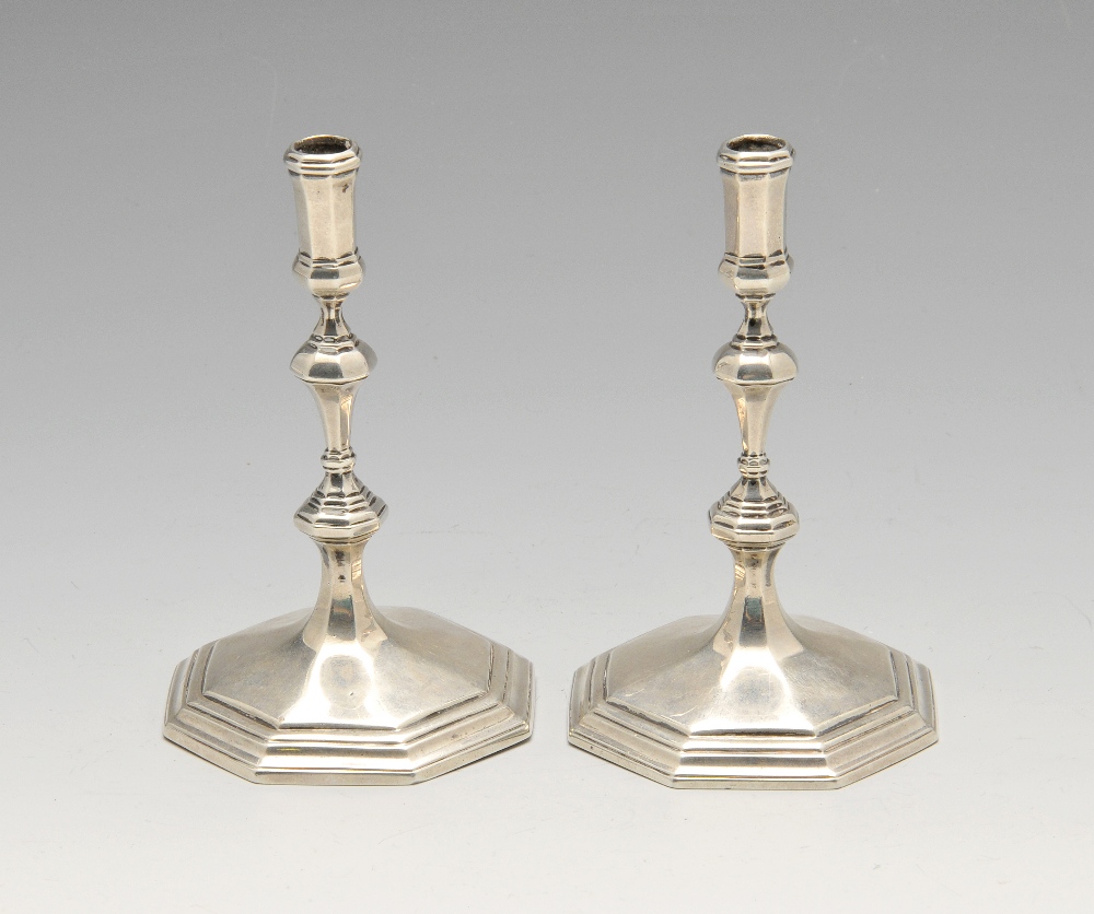 A pair of late Victorian silver tapersticks, the knopped baluster stems raised on stepped