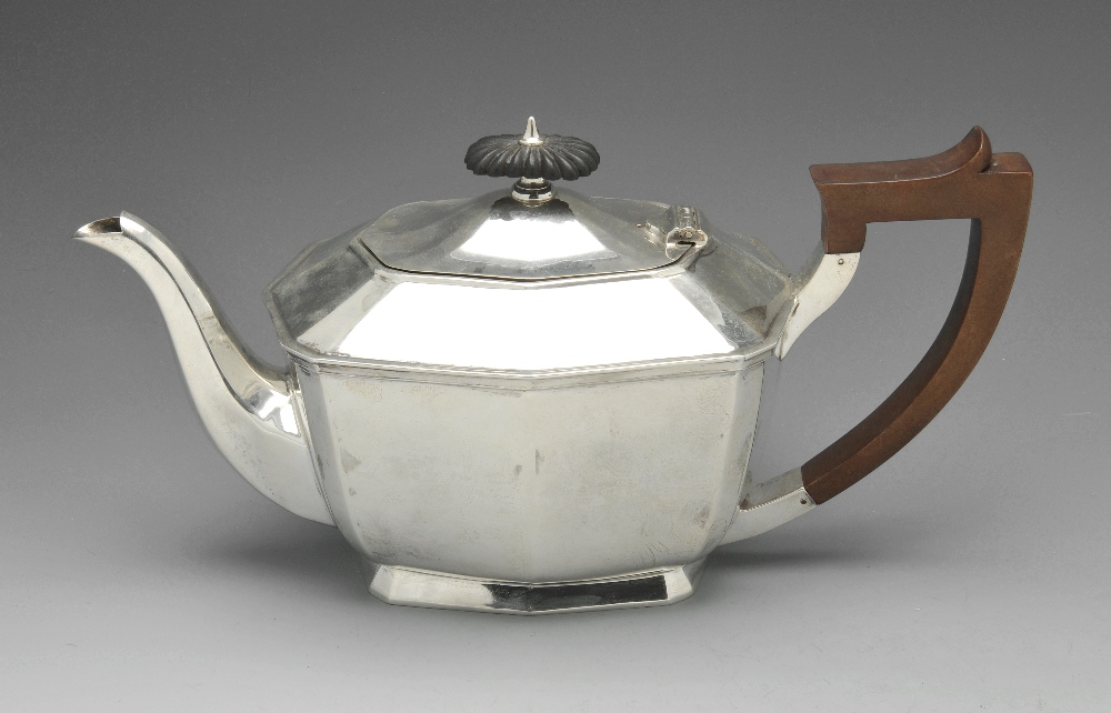 A 1930's silver teapot, of panelled form above a footed base and having applied scroll capped square