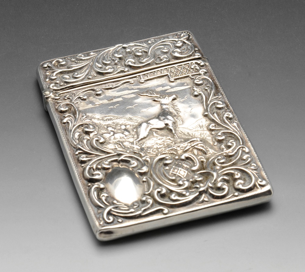 An Edwardian silver card case, the oblong form, embossed with a hillside scene of a stag and deer