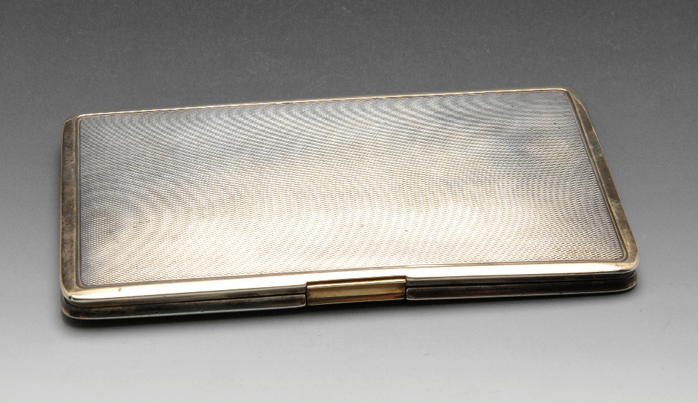 An early twentieth century silver cigarette case of oblong form and engine-turned decoration with