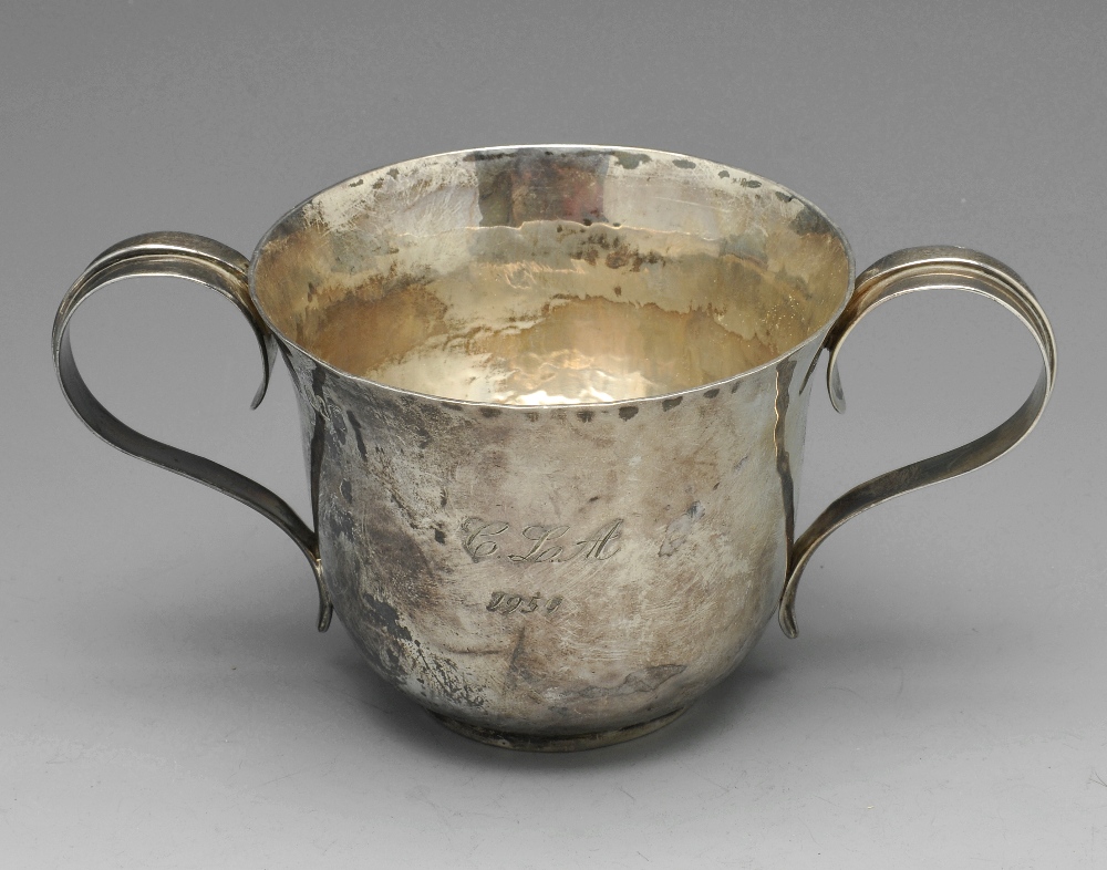 An Edwardian silver twin-handled cup of slightly flared form, having a planished finish with