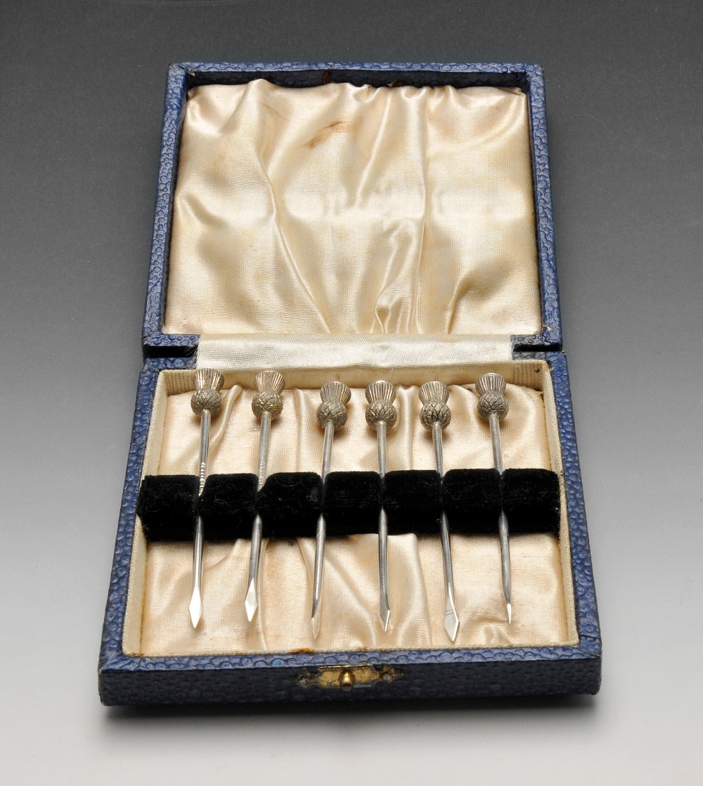 A 1930's cased set of six cocktail sticks with thistle terminals, hallmarked Birmingham 1934.