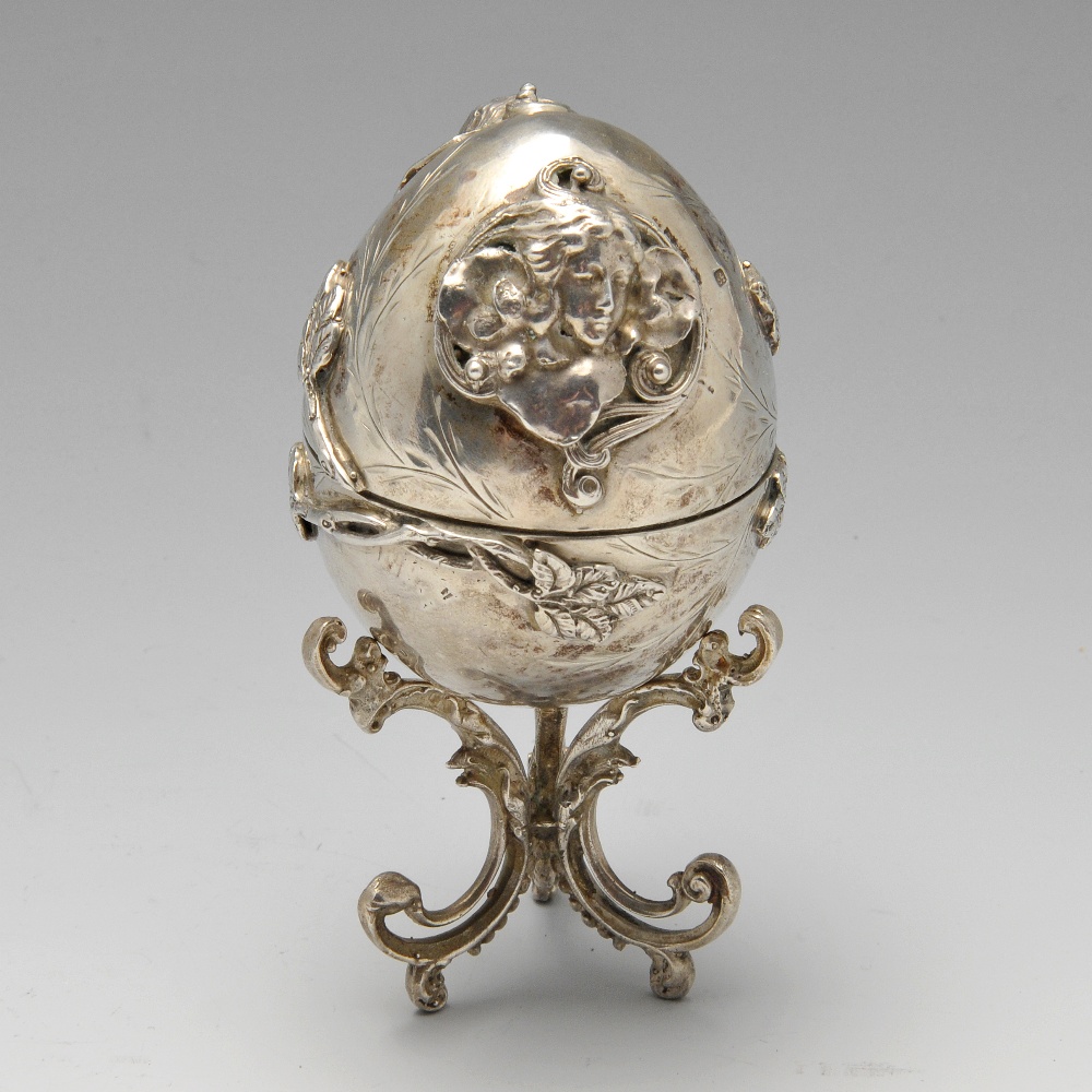 A late nineteenth century Eastern European egg ornament on stand, applied decoration of twin opposed