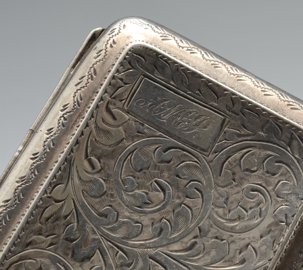 A 1920's silver cigarette case of rounded rectangular form, having foliate scroll engraving - Image 4 of 9