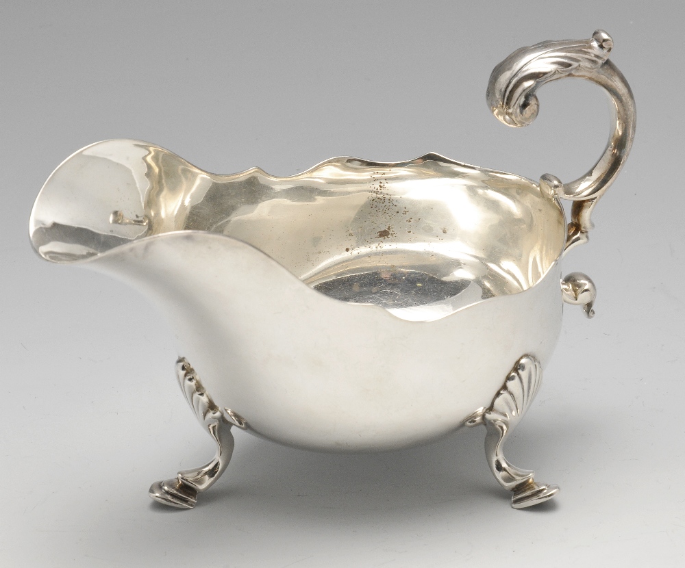 A late Victorian silver sauce boat, of typical bellied form with shaped rim, foliate capped flying