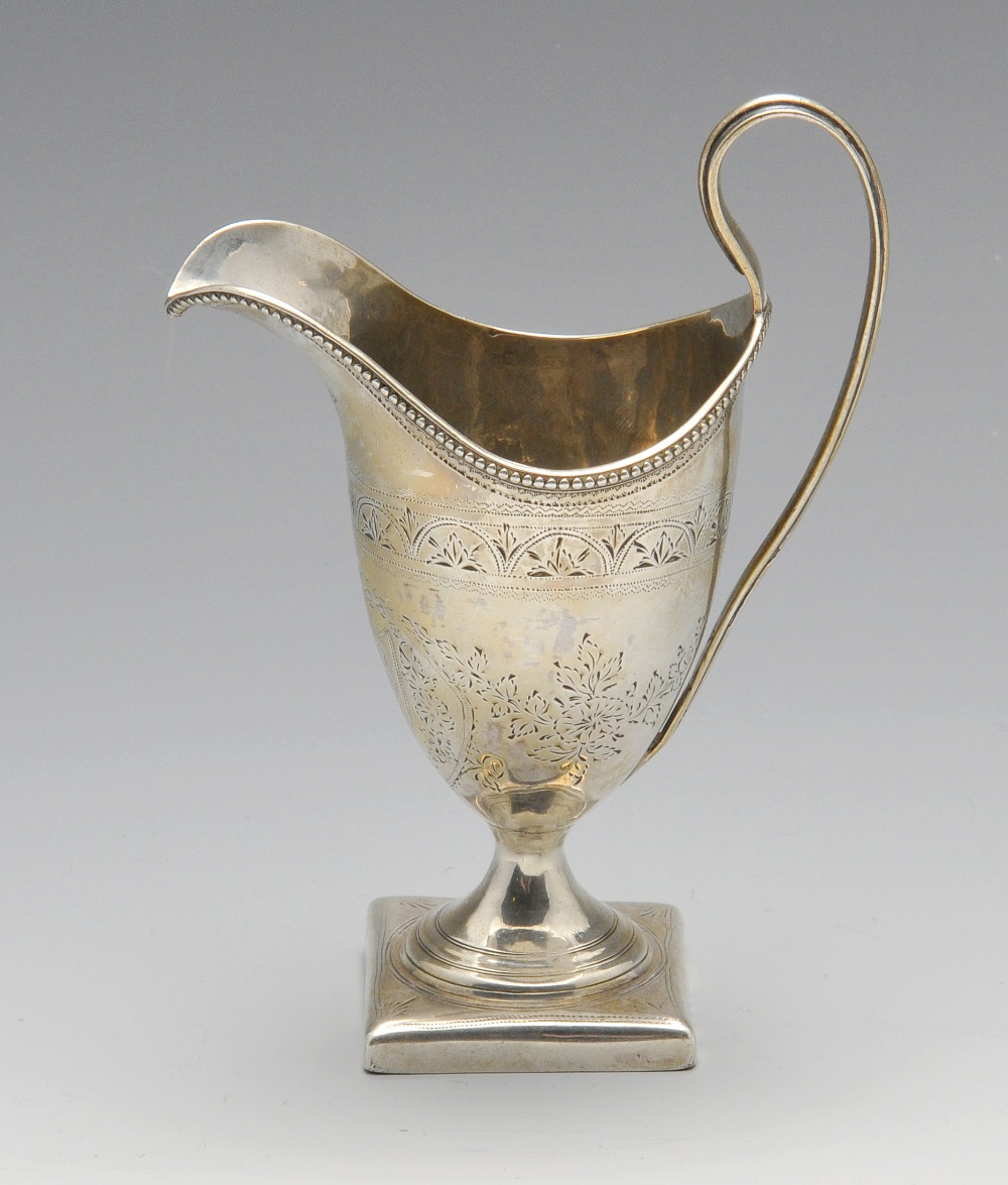 A George III silver helmet jug, the classic form with engraved floral and foliate borders,