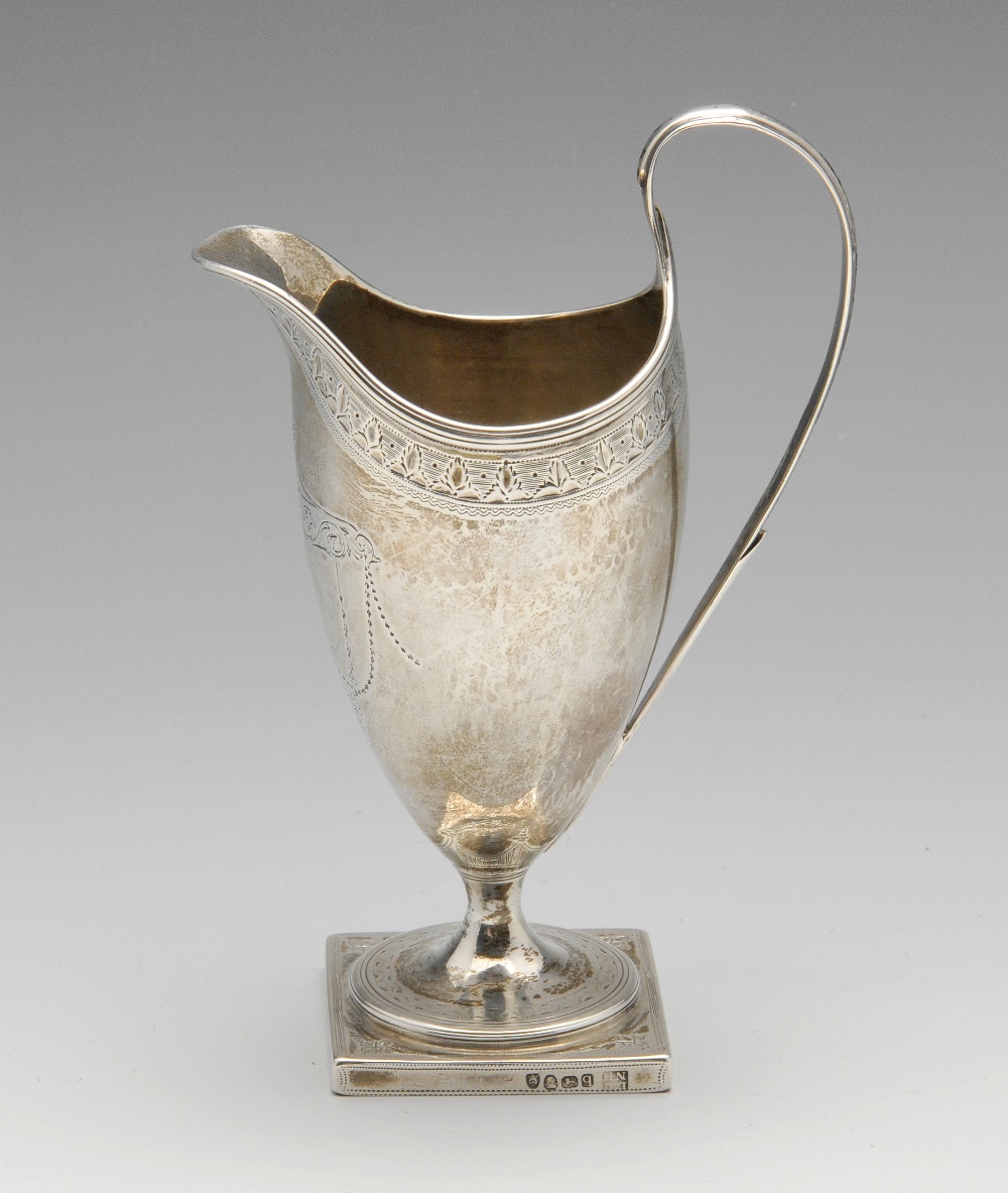 A George III silver helmet jug, the classic form with foliate border, reeded rim, garland surround