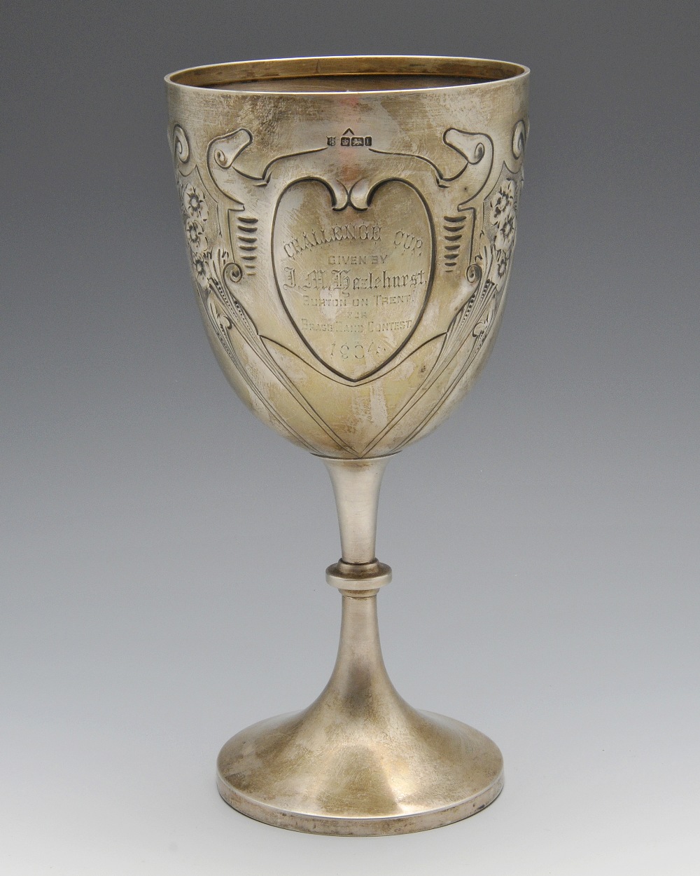 An Edwardian silver trophy cup, the goblet form with Art Nouveau embossed decoration surrounding the