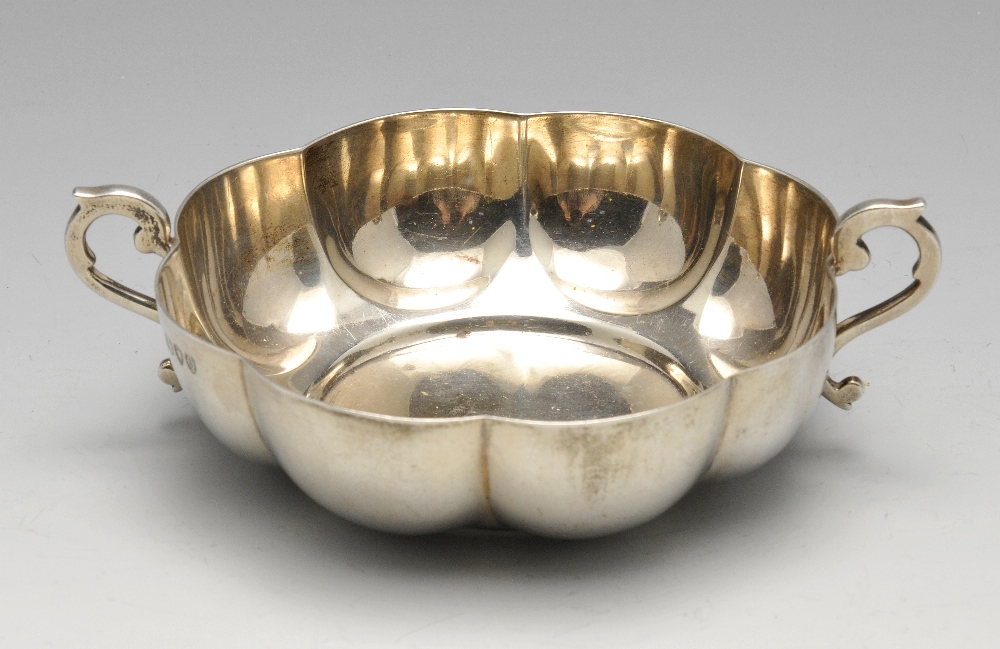 A Victorian silver christening bowl, the circular lobed body with twin scrolling handles. Hallmarked